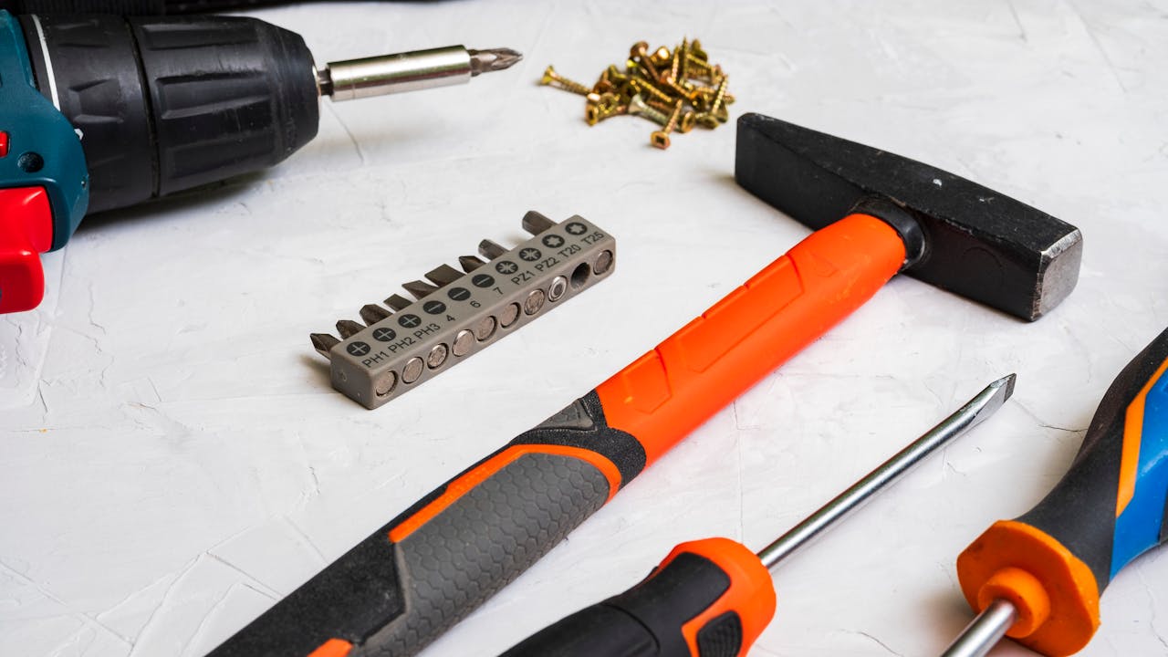 A selection of hand tools including a hammer, screwdriver, and drill bits for home improvement projects.